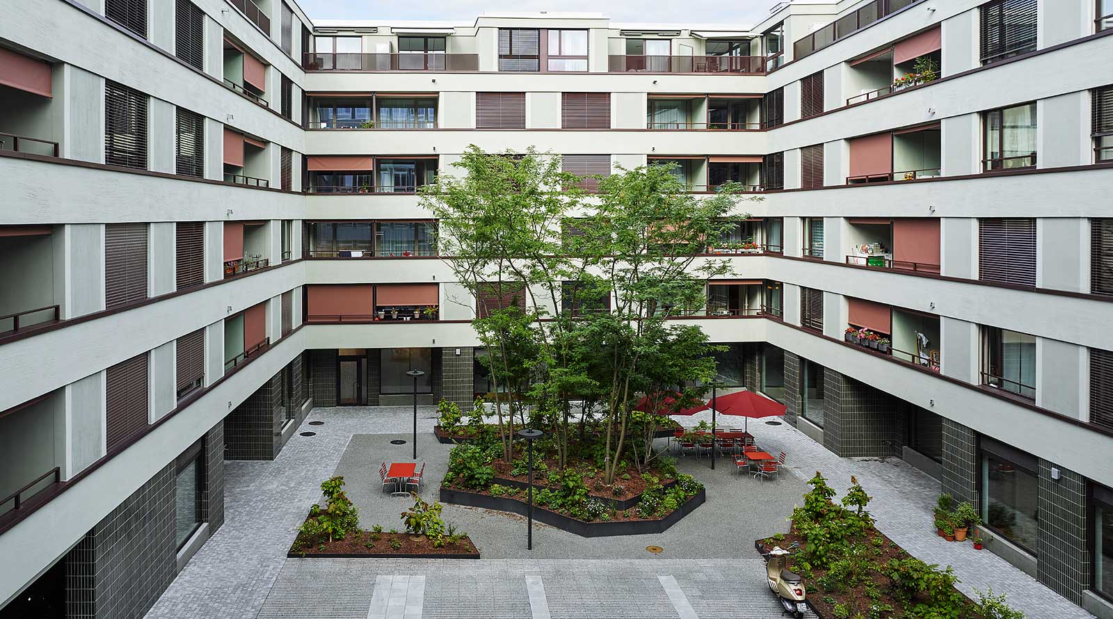 Im begrünten Innenhof stehen Tische und Gartenstühle für spontane Treffen bereit. Foto: Georg Aerni.