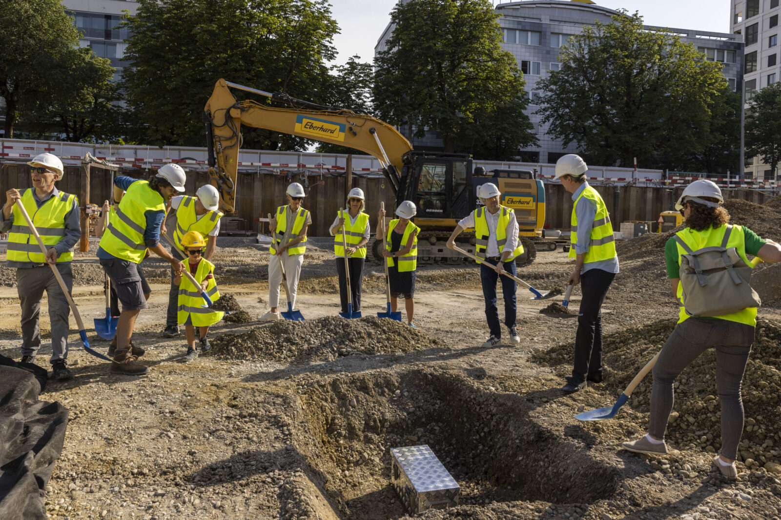 Die Grundsteinkapsel wird von den Beteiligten Planer- und Architektenteams und den Kooperationspartnerinnen mit Erde bedeckt (Foto: Niklaus Spoerri).